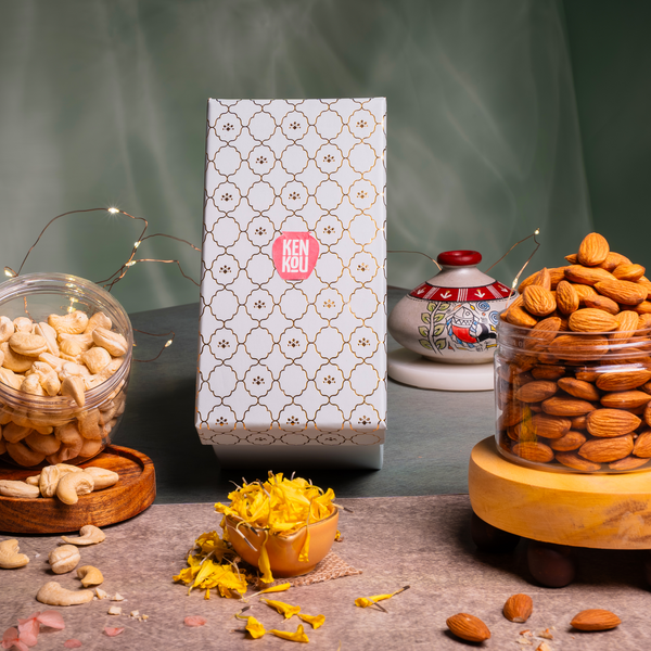 Two jars of nuts with a decorative box in the center on a dark surface.